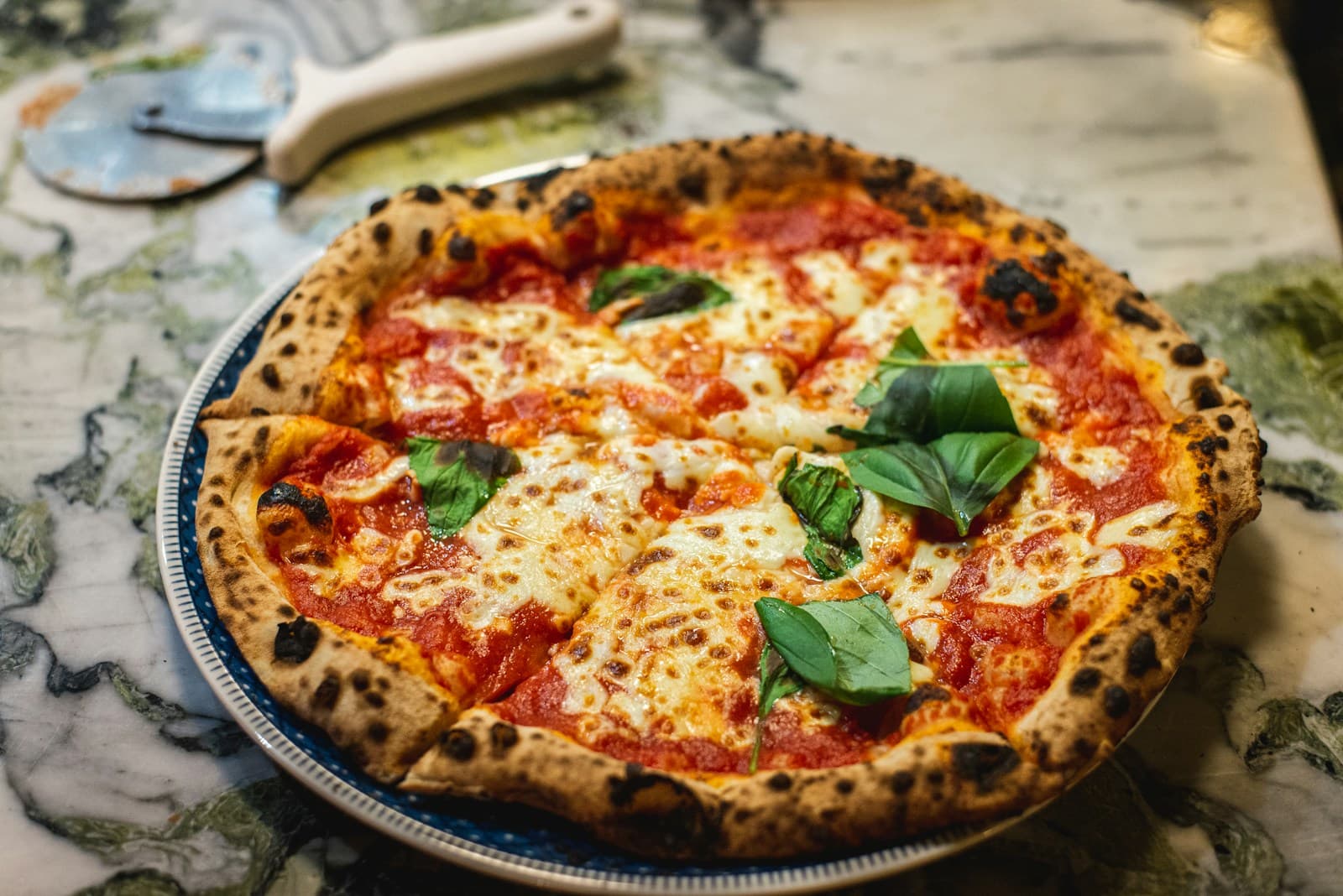 Pizza being placed into a wood-fired stone oven